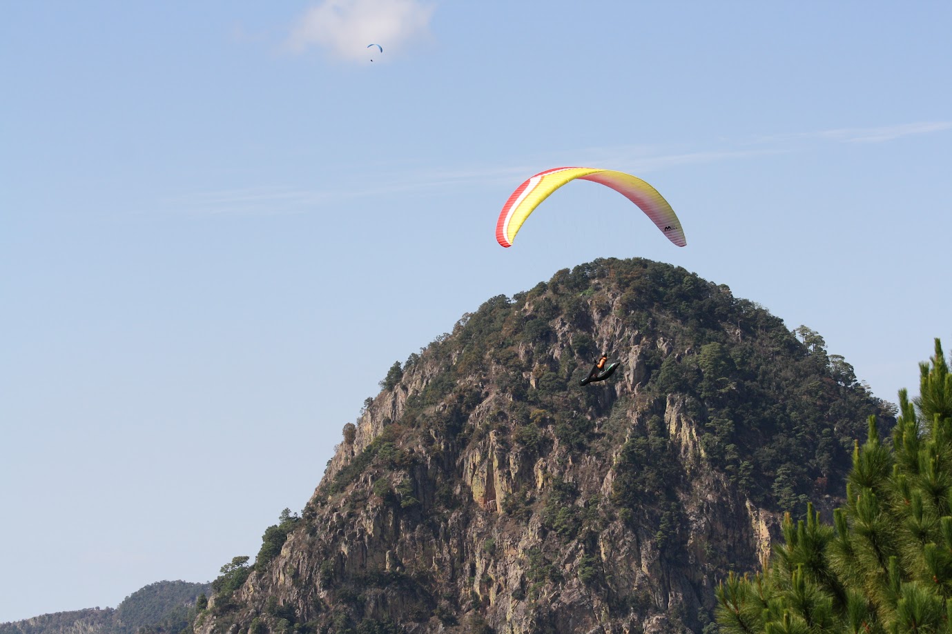 Paraglider soaring over El Penon in Valle de Bravo, Mexico