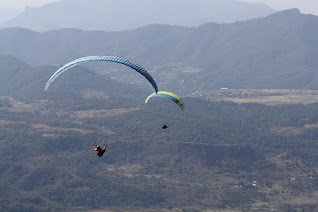Paragliders soaring over mountain terrain