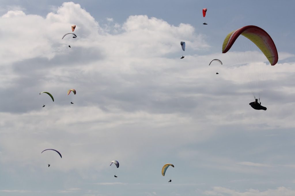 Gaggle of paragliders thermalling together over Valle de Bravo